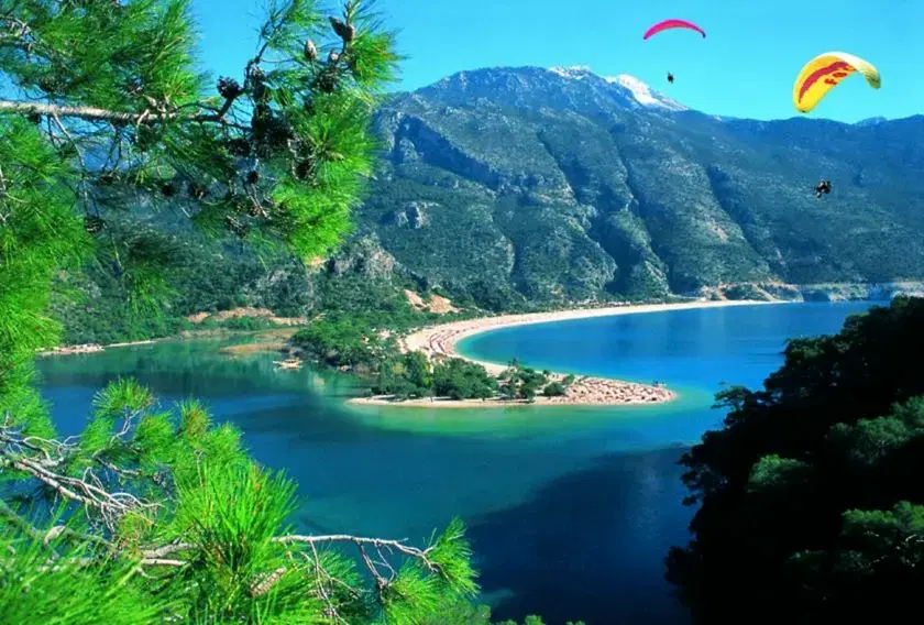 Aerial view of Marmaris coastline, marina, and surrounding green hills during a helicopter transfer from Antalya